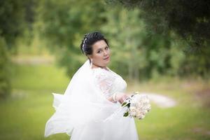 Beautiful fat bride posing against the backdrop of nature. photo