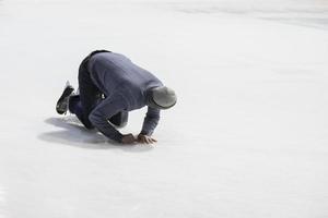 The man fell while skating on the ice. photo