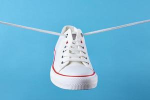 White casual sneakers on blue background, creative minimalism photo