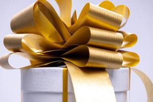 un regalo caja con un dorado arco foto