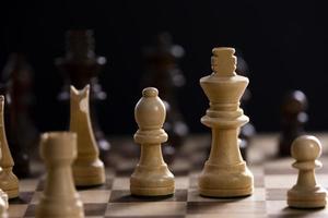 A chess board asnd pieces against black background photo