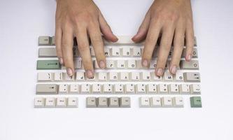 Hands typing with loose keys from a classic office computer keyboard photo