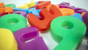 Macro shot of multi coloured magnetic numbers on plain white background photo