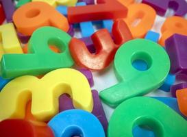 Macro shot of multi coloured magnetic numbers on plain white background photo