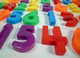 Macro shot of multi coloured magnetic numbers on plain white background photo