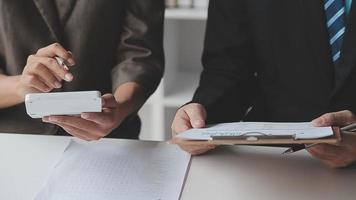 financiële analisten analyseren zakelijke financiële rapporten over een investeringsproject voor digitale tabletplanning tijdens een discussie op een bijeenkomst van bedrijven die de resultaten van hun succesvolle teamwerk laten zien. video