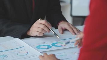 Financial analysts analyze business financial reports on a digital tablet planning investment project during a discussion at a meeting of corporate showing the results of their successful teamwork. video