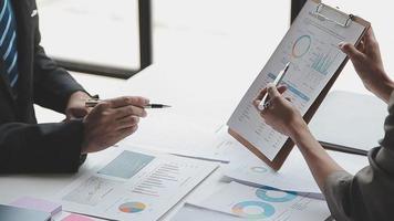 Financial analysts analyze business financial reports on a digital tablet planning investment project during a discussion at a meeting of corporate showing the results of their successful teamwork. video