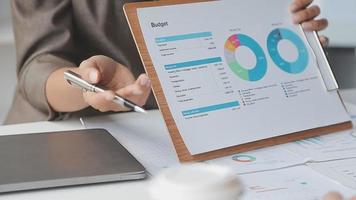 Financial analysts analyze business financial reports on a digital tablet planning investment project during a discussion at a meeting of corporate showing the results of their successful teamwork. video