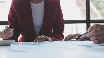 Financial analysts analyze business financial reports on a digital tablet planning investment project during a discussion at a meeting of corporate showing the results of their successful teamwork. video