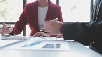 Financial analysts analyze business financial reports on a digital tablet planning investment project during a discussion at a meeting of corporate showing the results of their successful teamwork. video