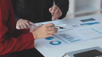 Financial analysts analyze business financial reports on a digital tablet planning investment project during a discussion at a meeting of corporate showing the results of their successful teamwork. video