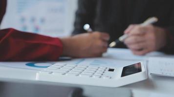 Financial analysts analyze business financial reports on a digital tablet planning investment project during a discussion at a meeting of corporate showing the results of their successful teamwork. video