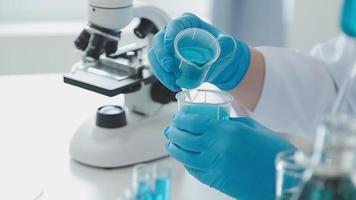 Science and medicine, scientist analyzing and dropping a sample into a glassware, experiments containing chemical liquid in laboratory on glassware, DNA structure, innovative and technology. video