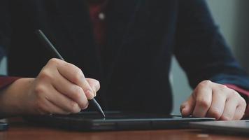 Business partnership coworkers using a tablet to chart company financial statements report and profits work progress and planning in office room. video