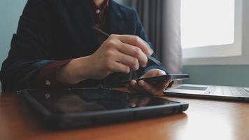 Business partnership coworkers using a tablet to chart company financial statements report and profits work progress and planning in office room. video