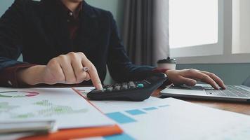 Teamwork of asian business people discussing and calculating with calculator on evaluation data in conference room. with the growth and pointing to the chart graph financial account. video