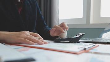 Teamwork of asian business people discussing and calculating with calculator on evaluation data in conference room. with the growth and pointing to the chart graph financial account. video