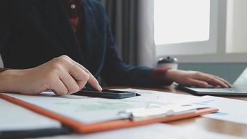 Teamwork of asian business people discussing and calculating with calculator on evaluation data in conference room. with the growth and pointing to the chart graph financial account. video