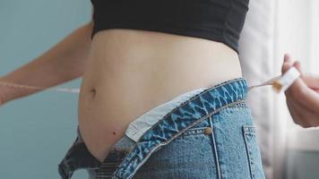 Bauch stecken, schlaff Haut auf ein Fett Bauch, Plastik Chirurgie Konzept auf grau Hintergrund video