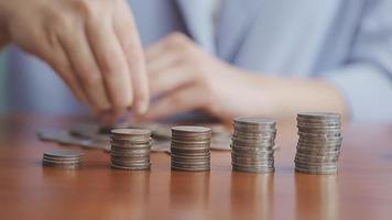 Businessman hand pressing calculator putting coins on pile saving savings for retirement future video