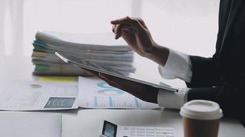 Financial analysts analyze business financial reports on a digital tablet planning investment project during a discussion at a meeting of corporate showing the results of their successful teamwork. video