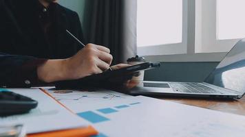 Financial analysts analyze business financial reports on a digital tablet planning investment project during a discussion at a meeting of corporate showing the results of their successful teamwork. video