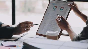 Financial analysts analyze business financial reports on a digital tablet planning investment project during a discussion at a meeting of corporate showing the results of their successful teamwork. video