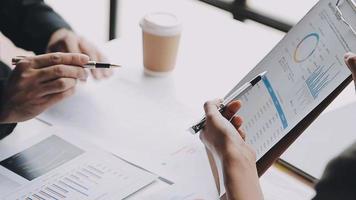 Financial analysts analyze business financial reports on a digital tablet planning investment project during a discussion at a meeting of corporate showing the results of their successful teamwork. video