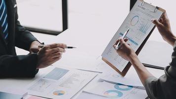 Financial analysts analyze business financial reports on a digital tablet planning investment project during a discussion at a meeting of corporate showing the results of their successful teamwork. video