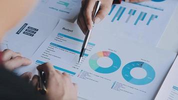 Financial analysts analyze business financial reports on a digital tablet planning investment project during a discussion at a meeting of corporate showing the results of their successful teamwork. video