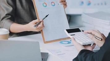 Financial analysts analyze business financial reports on a digital tablet planning investment project during a discussion at a meeting of corporate showing the results of their successful teamwork. video