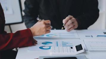 Financial analysts analyze business financial reports on a digital tablet planning investment project during a discussion at a meeting of corporate showing the results of their successful teamwork. video