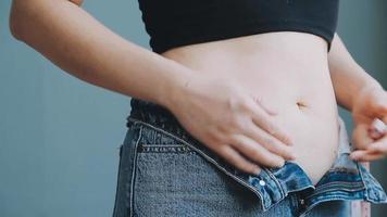 barriguita pliegue, flácido piel en un grasa barriga, el plastico cirugía concepto en gris antecedentes video