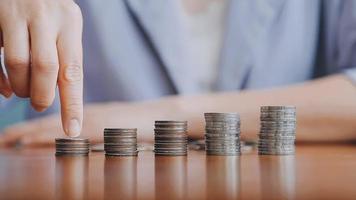 Businessman hand pressing calculator putting coins on pile saving savings for retirement future video