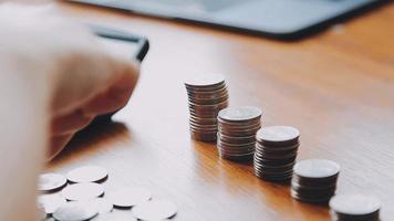 Businessman hand pressing calculator putting coins on pile saving savings for retirement future video