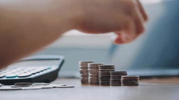 Businessman hand pressing calculator putting coins on pile saving savings for retirement future video