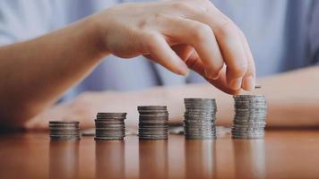 Businessman hand pressing calculator putting coins on pile saving savings for retirement future video