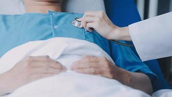 Doctor giving hope. Close up shot of young female physician leaning forward to smiling elderly lady patient holding her hand in palms. Woman caretaker in white coat supporting encouraging old person video