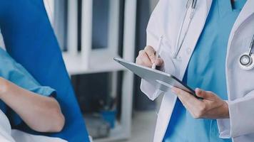 médico dando ter esperança. fechar acima tiro do jovem fêmea médico inclinado frente para sorridente idosos senhora paciente segurando dela mão dentro Palmeiras. mulher zelador dentro branco casaco apoiando encorajando velho pessoa video