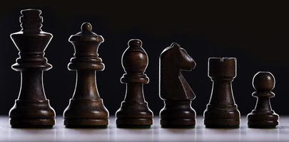 A chess board asnd pieces against black background photo