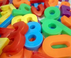 Macro shot of multi coloured magnetic numbers on plain white background photo