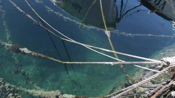 the ropes of a boat moored in a harbour in croatia in beautiful coloured water video