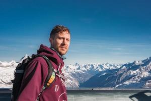 Young man at the peak of the Matterhorn Glacier Paradise. Exploring Swiss Alps from the top of the Glacier. photo