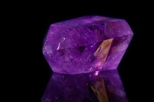 Macro mineral stone Amethyst crystal on a black background photo