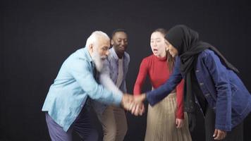 Smiling friends of different races and cultures socialize and rejoice. European men, Asian women, African hijab women and African men socialize, chat and have fun. video