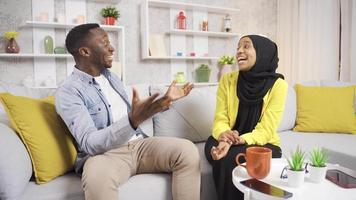 africano musulmán familia alegría a el bueno Noticias juntos. el joven musulmán mujer en hijab da bueno Noticias a su marido y ellos alegrarse a esta Noticias juntos. video