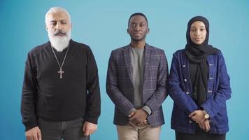 Portrait of a mature Christian man and African young Muslim man and young woman in brotherhood and piety. Portrait of Christian man and Muslim African couple. Friendship. video