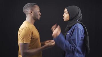 afrikanisch Muslim Paar streiten, Kampf und urteilen jeder andere auf schwarz Hintergrund. afrikanisch Jugend im beunruhigt Beziehungen Streit, nicht zustimmen und argumentieren. video