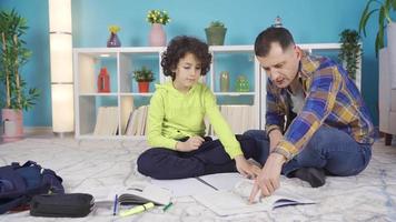 Family man helping boy at home with his lessons. Successful and smart kid. Father helping his son with school homework. Education and relationship, male teaching and boy learning concept. video